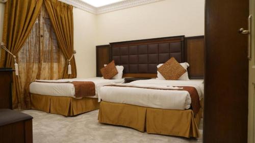 a hotel room with two beds and a window at شاطئ المرجان للشقق المخدومه in Quai