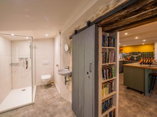 a bathroom with a book shelf with books at Carmagnac Cowshed in Vaux-Lavalette