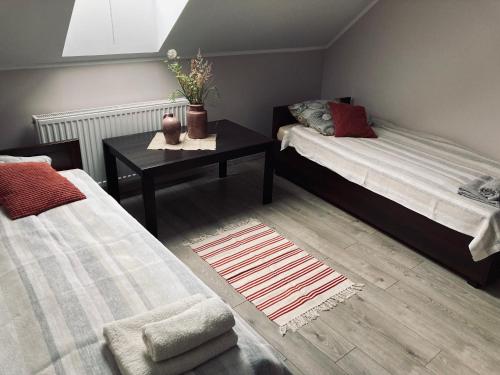 a room with two beds and a table with a table at Kamienica pod Rakiem in Żmigród