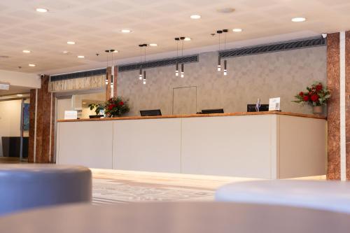 a large lobby with a large white reception desk at Grand Beach Hotel in Tel Aviv