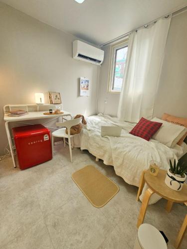 a bedroom with a bed and a desk with a laptop at The Stay 150 Anyang in Anyang