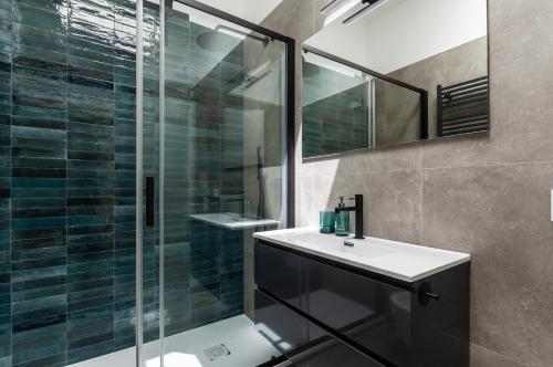 une salle de bain avec un lavabo et une douche en verre dans l'établissement Youhosty - Zanella 68, à Milan