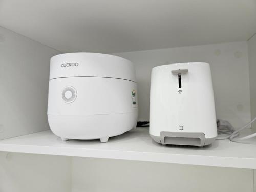 two white printers sitting on a shelf next to each other at The Stay 150 Anyang in Anyang