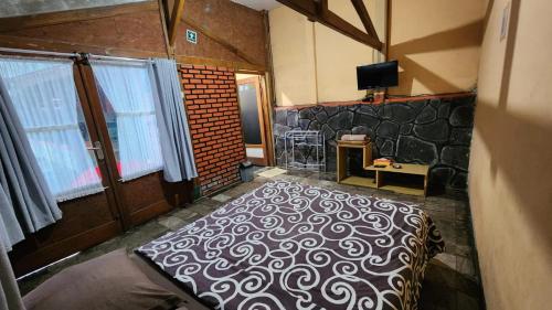 a bedroom with a bed with a black and white blanket at Nur Alam Hotel Lembang in Lembang