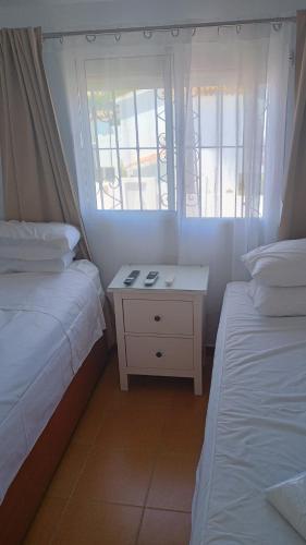 Habitación pequeña con 2 camas y mesita de noche en Centro Kennedy, en Algeciras