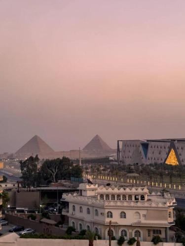 a view of a city with pyramids in the background at Fancy Pyramids View Khan Giza's Gem in Cairo