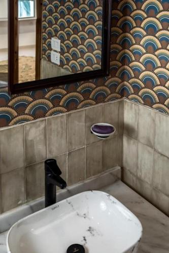 a bathroom with a white sink and a mirror at Fancy Pyramids View Khan Giza's Gem in Cairo