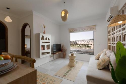 a living room with a couch and a large window at Fancy Pyramids View Khan Giza's Gem in Cairo