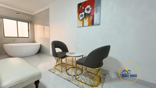 布拉瓦约Hardy House- Kent的一间带两把椅子和一张桌子的浴室以及浴缸