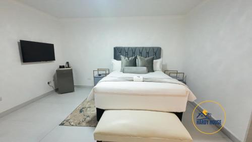 布拉瓦约Hardy House- Kent的一间带床和电视的白色卧室