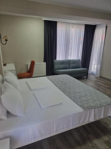 a bedroom with a large bed and a couch at Picasso in Shekvetili