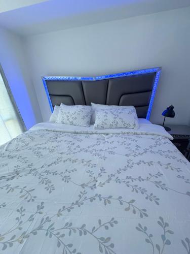 a bed with a blue headboard and pillows on it at CN Tower & Lake views, 1 bedroom plus den in Toronto
