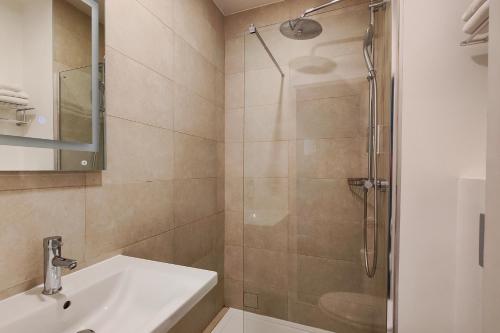 a bathroom with a sink and a shower at Hôtel Du Centre, un hôtel AMMI in Nice