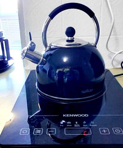 a black tea kettle sitting on top of a stove at St Tropez on the beach in Strand