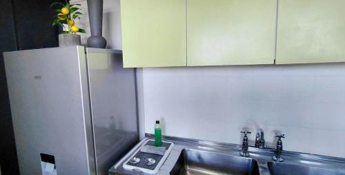 a kitchen with a sink and a refrigerator at St Tropez on the beach in Strand