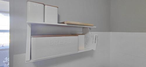 a white kitchen with a shelf on the wall at St Tropez on the beach in Strand