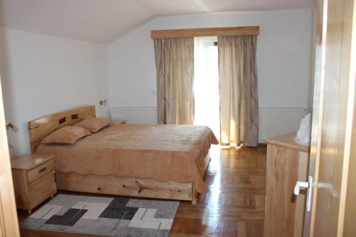 a bedroom with a large bed and a window at Casa la grig in Râşnov