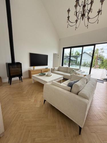 un salon avec un canapé et une télévision dans l'établissement Villa IBIZA, à Śmiechów