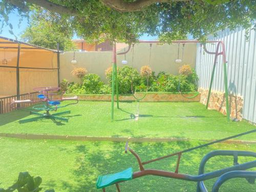 a backyard with a swing set and a playground at Chalet Adam- Ajloun شاليه ادم in Ajloun
