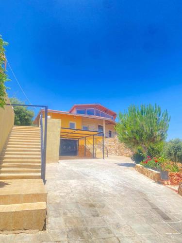 a house with a staircase in front of it at Chalet Adam- Ajloun شاليه ادم in Ajloun