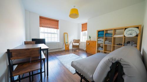 a bedroom with a desk and a bed and a table at Cosy Flat in the Heart of Greenwich in London
