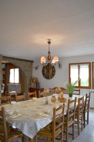 a dining room with a table with chairs and a chandelier at APPARTEMENT MOUFLONS in La Llagonne