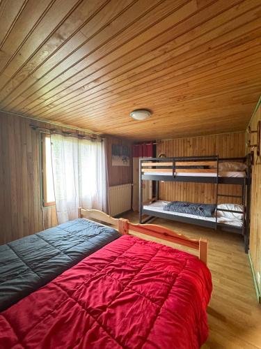 une chambre avec un lit dans une pièce en bois dans l'établissement APPARTEMENT MOUFLONS, à La Llagonne