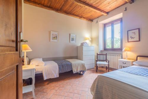 una camera da letto con due letti, una scrivania e una finestra di Ai due Cedri a Capranica