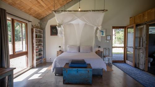a bedroom with a bed with a canopy at Never Never Cabin in Gleniffer