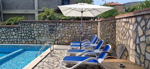 a group of chairs and an umbrella next to a pool at Family hotel Favourite in Obzor