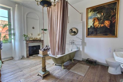 a bathroom with a tub and a horse painting on the wall at Chateau Ciers in Saint-Ciers-sur-Gironde