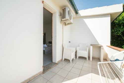 a room with a table and chairs on a patio at Villa D'Oro in La Maddalena