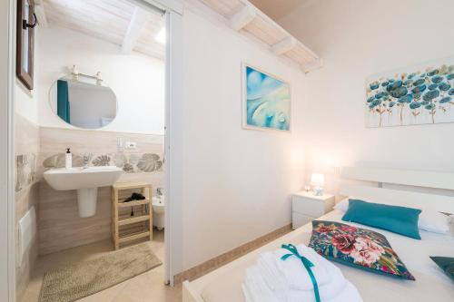 a bedroom with a bed and a sink and a mirror at Villa D'Oro in La Maddalena