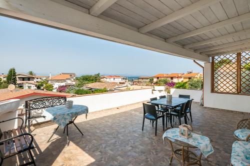 a patio with tables and chairs and a balcony at Villa D'Oro in La Maddalena