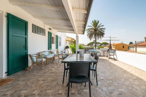 a patio with tables and chairs and a green door at Villa D'Oro in La Maddalena