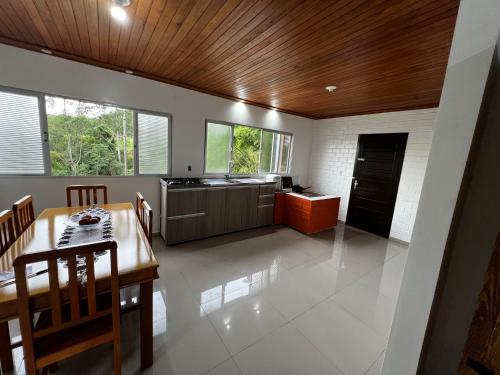 a kitchen and dining room with a wooden ceiling at Casa da Figueira in Louro Müller