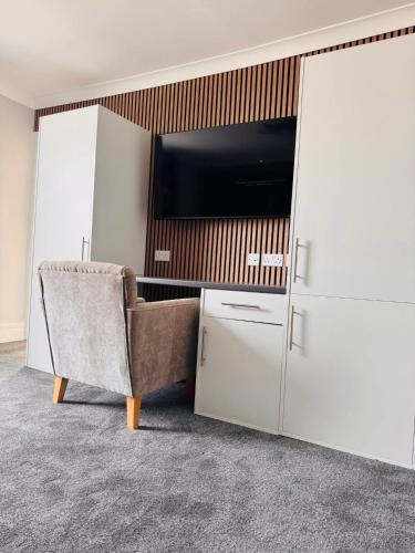 a living room with a tv and a chair at Thomas Arms Hotel in Llanelli