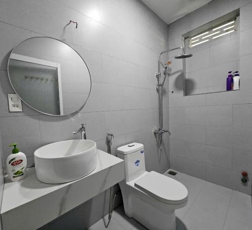 a bathroom with a sink and a toilet and a mirror at Bắp's House Đà Lạt in Da Lat
