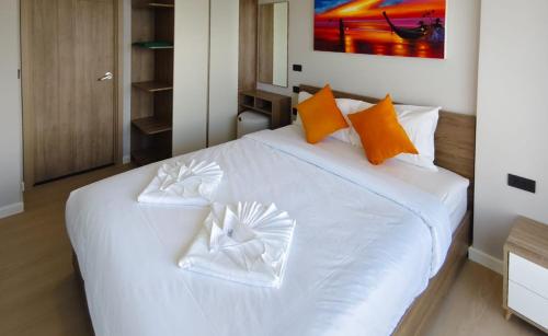 Ban Thalat Choeng ThaleにあるSpace Cherngtalay Condo in Elegant Bang Taoの白いベッド(オレンジと白の枕付)
