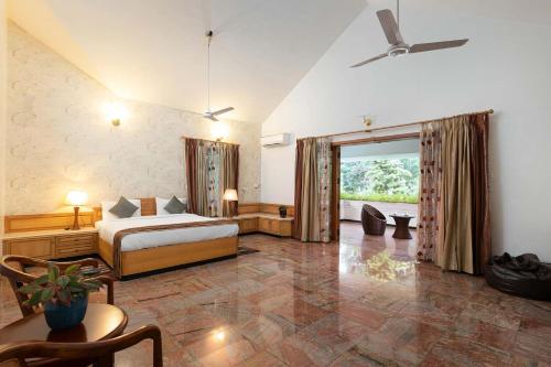 a bedroom with a bed and a ceiling fan at Dwaraka inn -Premium Pool villa and event venue in Coimbatore