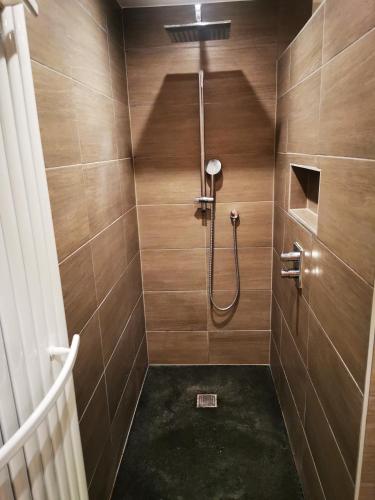 ein Badezimmer mit Dusche und Holzwänden in der Unterkunft Cor-U in Dessel