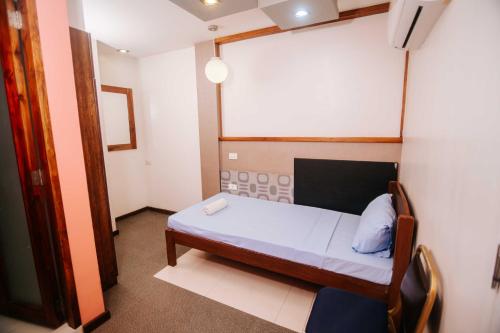 Ένα ή περισσότερα κρεβάτια σε δωμάτιο στο Villa Rosita Hotel Naga City by RedDoorz