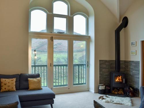 a living room with a couch and a fireplace at Howegrain Lodge in Glenridding