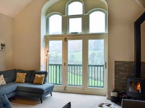 a living room with a couch and a fireplace at Howegrain Lodge in Glenridding