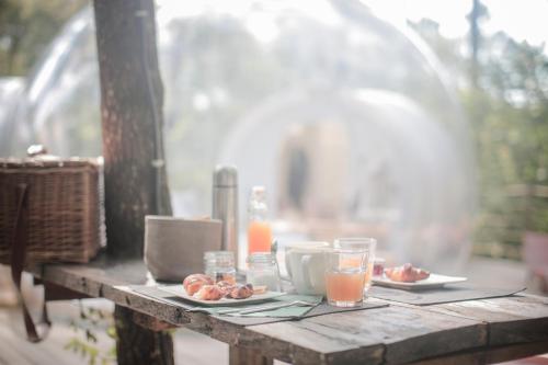 een tafel met borden eten en glazen sinaasappelsap bij Les Bulles De Bordeaux in Salleboeuf