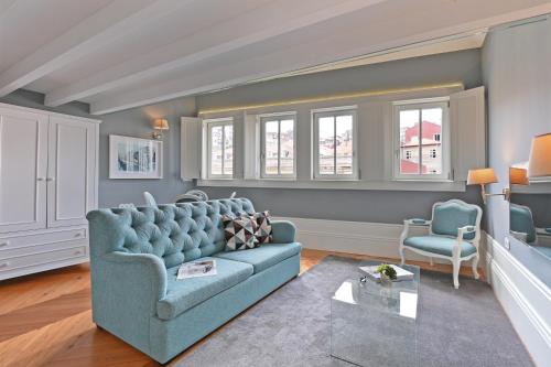 a living room with a blue couch and a chair at Villa Mouzinho by ON Apartments in Porto