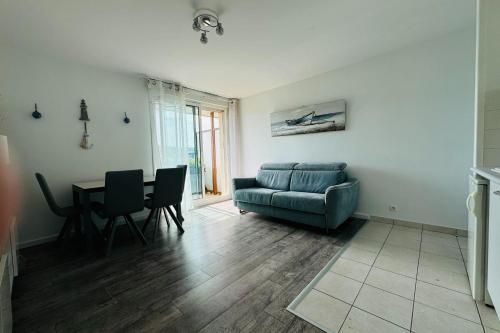 un salon avec un canapé et une table dans l'établissement Beautiful studio with terrace - harbour view, à Ouistreham