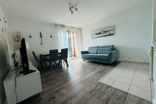 un salon avec un canapé et une table dans l'établissement Beautiful studio with terrace - harbour view, à Ouistreham