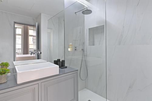 a white bathroom with a sink and a shower at Villa Mouzinho by ON Apartments in Porto