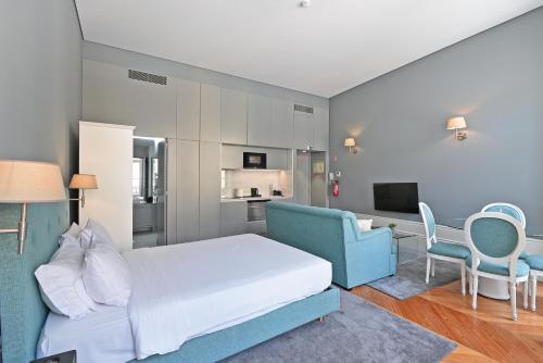 a bedroom with a bed and a couch and a tv at Villa Mouzinho by ON Apartments in Porto